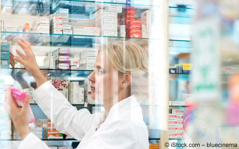 Apothekerin schaut auf ein Medikament Apothekerin schaut auf ein Medikament